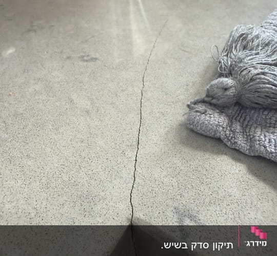 סדק במשטח שיש עם מטלית אפורה בצד